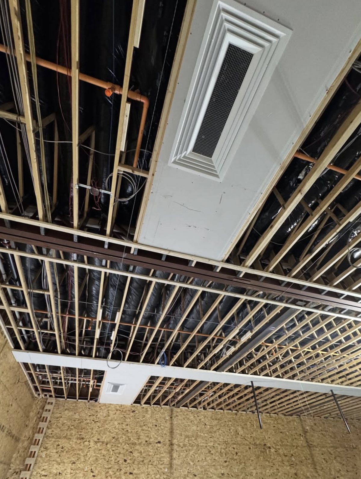 Supply diffuser mounted flush with a finished gymnasium ceiling