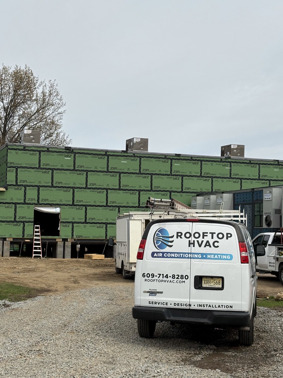 Rooftop HVAC van beside a modular gymnasium under construction