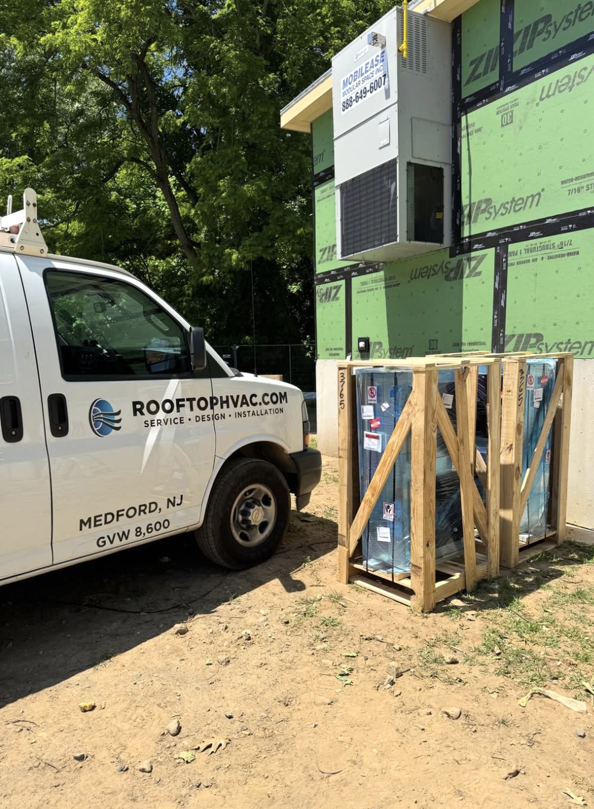 Wall-mount unit on a modular building with a Rooftop HVAC van alongside