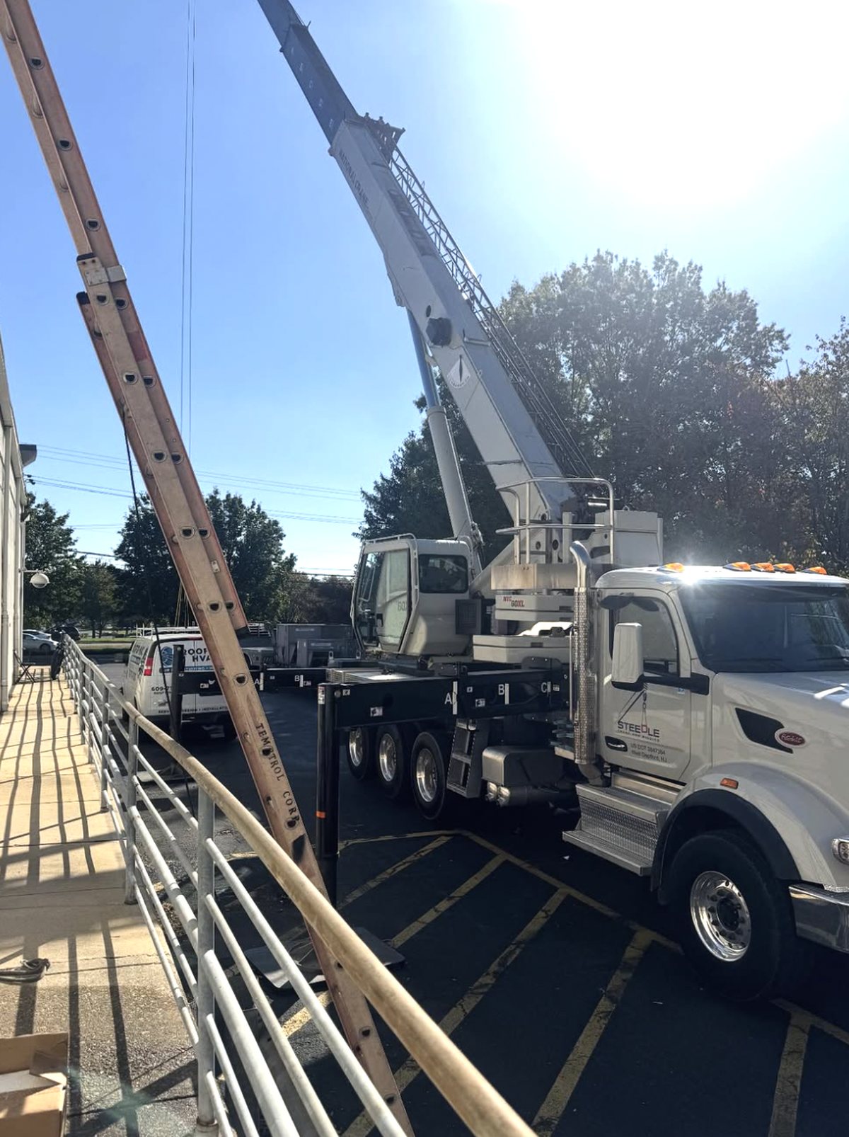 Crane staged in the parking lot of an occupied retail center